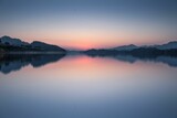 Fototapeta Do pokoju - a lake with a mountain and a sunset in the background