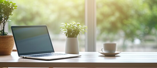 Aufkleber - The Home Office Concept portrays a designated area for working from home, situated near a window. It features a modern laptop with a blurred screen and a glass cup of tea on the table. is a close-up