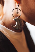 Decorative Earring In The Shape Of The Moon Hanging In A Woman's Ear. Fashion Details And Accessories
