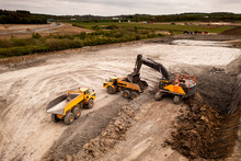 Aerial View Above A Digger And Dumper Truck On A Brownfield Site In The Construction Industry