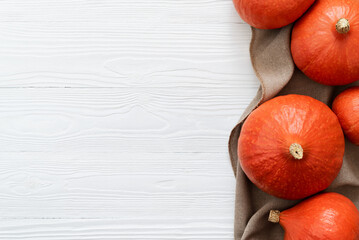Wall Mural - Harvest of Red Kuri Squash on a White Wooden Background