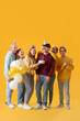 © Pixel-Shot - Group of young friends celebrating Birthday on yellow background