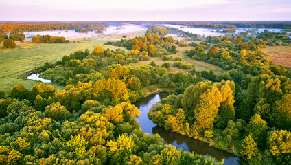 Wall Mural - Aerial summer sunrise view. Rural landscape, river meandering in forest green trees. Morning Misty Scene. Serene atmosphere fog panorama. Agriculture fields, wood on riverbank