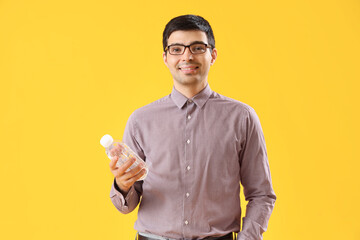 Canvas Print - Young man with bottle of water on yellow background