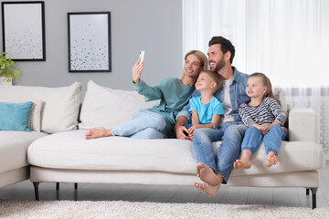 Canvas Print - Happy family taking selfie together on sofa at home