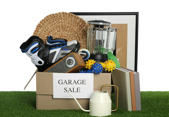 Wall Mural - Box with sign Garage Sale and different stuff on green grass against white background