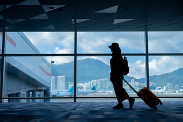 Wall Mural - Young woman traveler looking at the airplane at the airport, Travel concept