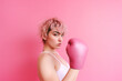 Woman with pink short hair wearing pink boxing gloves in support of breast cancer awareness. Created with Generative AI technology