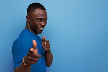 Poster - young attractive african man dressed in t-shirt on studio background with copy space