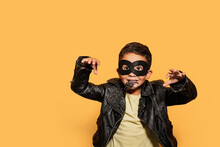 Adorable Child In Halloween Costume Holding Spider On Yellow Background Isolated
