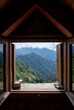 The view the green mountains from the window in a small hut, Bivacco, in the Italian Alps.
