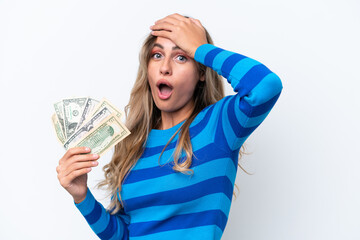 Canvas Print - Young Uruguayan woman taking a lot of money isolated on white background doing surprise gesture while looking to the side