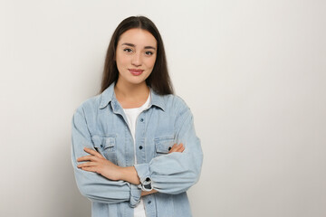 Wall Mural - Portrait of beautiful young woman in jeans jacket on white background. Space for text