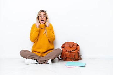 Sticker - Uruguayan student woman sitting one the floor isolated on white background celebrating a victory in winner position