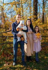 Wall Mural - a big family posing together in an autumn city park, children and parents, happy people enjoying beautiful nature, a bright sunny day and yellow leaves