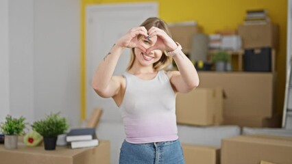 Poster - Young blonde woman doing heart gesture at new home