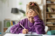 © Mediaphotos - Little girl sitting at her desk and making notes in copybook, she doing her homework