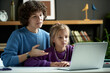 © Mediaphotos - Mother explaining school material to her daughter pointing at laptop while they sitting at desk during their study