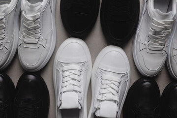 Six pairs of black and white sneakers on the floor. Casual fashion style minimalistic shoes.