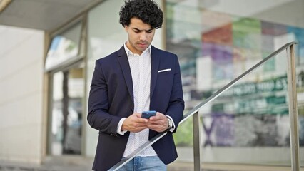 Sticker - Young latin man business worker using smartphone at street