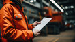 © Malika - Man in an orange jacket is reading a sheet of paper at the industrial plant