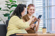 © Bangkok Click Studio - Asian young beautiful daughter sitting on cozy sofa holding touchscreen smartphone using credit card paying payment online via internet in living room at home with senior fat chubby pensioner mother