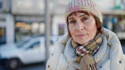 Sticker - Mature hispanic woman standing with serious expression at street