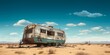 © Kevin - Living in remote destinations. An abandoned motor home or camping truck, in the middle of dry land or desert. Beautiful blue sky above. Generative AI