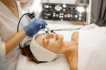 Young woman during facial microcurrent procedure, close-up view on face and special electrodes. Microcurrent facials for lifting effect, beauty skin treatment