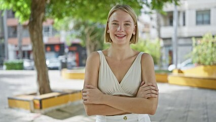 Sticker - Young blonde woman standing with arms crossed gesture smiling at park