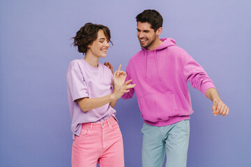 Beautiful couple dancing isolated over purple background