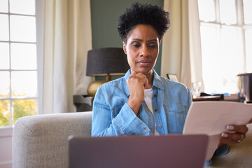 Wall Mural - Worried Mature Woman At Home With Laptop Looking At Household Bills In Cost Of Living Crisis