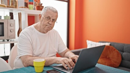 Poster - Middle age grey-haired man using laptop smiling at dinning room