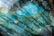 This is a colorful macro photo of a luminous and iridescent labradorite stone.  The patterns and otherworldly blue colors give it a science fiction landscape look. 