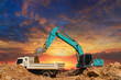 Crawler Excavator digging the soil into a truck ,In the construction site on sunset sky background