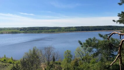 Sticker - Aerial landscape of lake surrounded by green nature on a sunny day