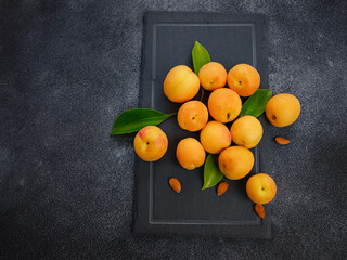 Wall Mural - Delicious ripe Fresh juicy apricots on black background, close-up. Selection of healthy vegetarian food, detox or diet concept. View from above, top studio shot