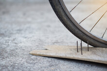 Close Up Nails On Wood Board And Flat Bicycle Tire. Concept, Unsafe , Damage. Be Careful And Look Around During Cycling On The Floor Or Risk Places. Accident Can Be Happened.           
