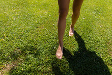 Bare Feet Trampling A Green Meadow
