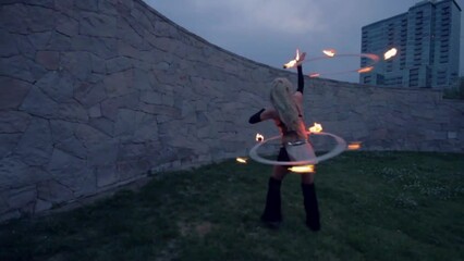 Poster - Professional female fire dancer performing with flames during a festival, slow motion