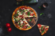 © elenavah - Pizza with ham,tomatoes and mozzarella on a dark background