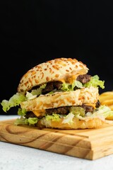 Poster - a cheeseburger on a cutting board with fries and lettuce