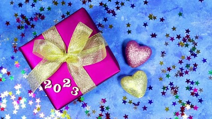 Wall Mural - happy new year 2024 background new year holidays card with bright lights, gift box and heart glitters toys with stars confetti and woman hand move the number 3 and put number four 