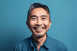 © Loks - Asian mid adult man smiling on a blue background