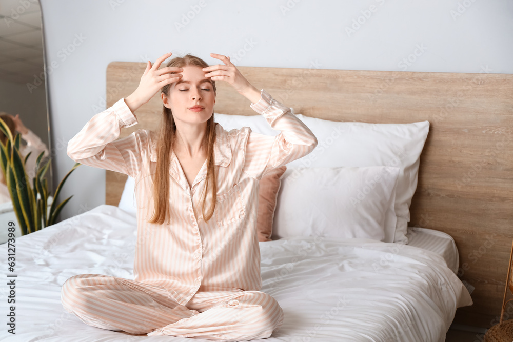 Young woman doing face building exercise in bedroom
