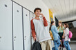 © LIGHTFIELD STUDIOS - happy schoolboy with braces having phone call, talking on smartphone in school hallway, blur