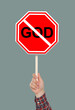 © New Africa - Atheism concept. Man holding prohibition sign with crossed out word God on grey background