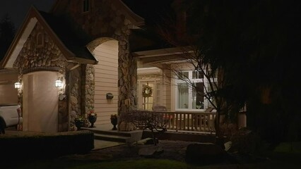 Wall Mural - Establishing shot of two story stucco luxury house with garage door, big tree and nice landscape at night in Vancouver, Canada, North America. Night time on Apr 2023. ProRes 422 HQ.