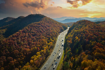 Wall Mural - Aerial view of I-40 freeway in North Carolina heading to Asheville through Appalachian mountains in golden fall with moving trucks and cars. Interstate transportation concept