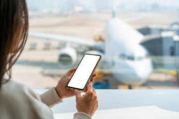 young asian woman traveler using smart phone while waiting for her flight at the airport